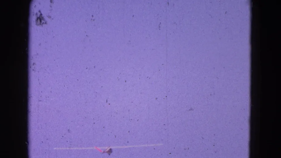 1964 8mm home-movie frame from Washington, DC area showing a small aircraft low in frame beneath a purple-blue sky.