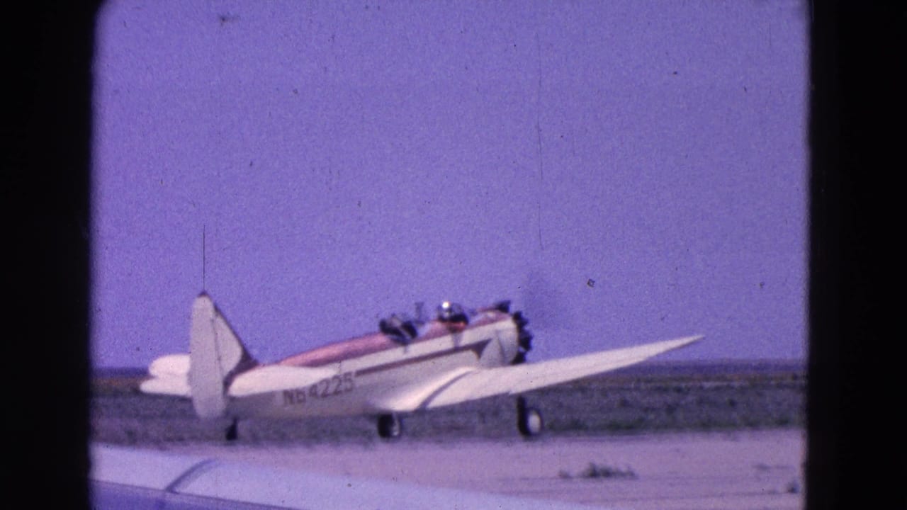Small white propeller plane with a red stripe on a runway under a purple-blue sky.
