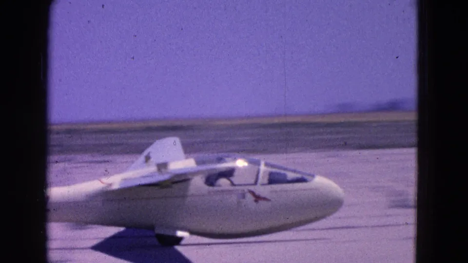 Closer 8mm frame of the glider nose, cockpit, and wing while taxiing on the runway in Washington DC metadata context.