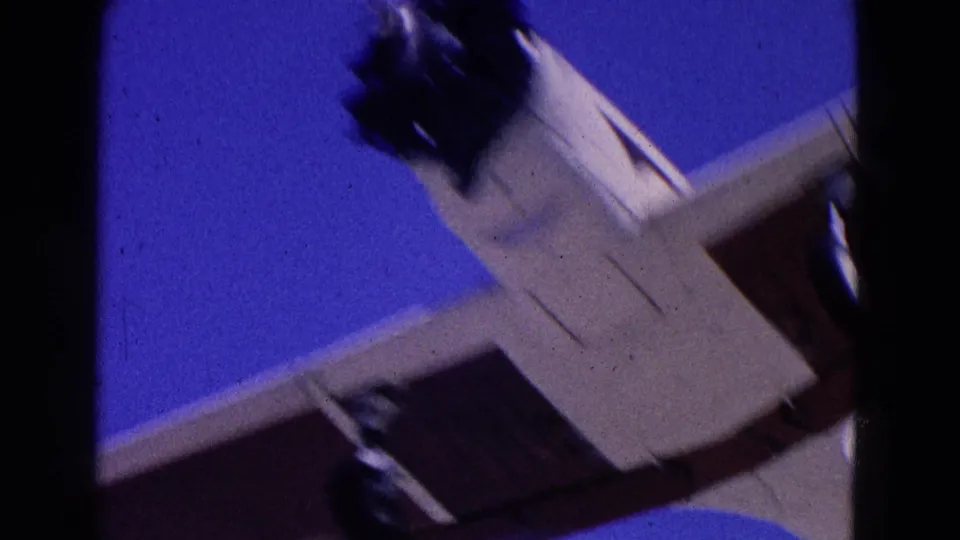 Close overhead 8mm view of a small propeller airplane passing above, showing the underside, wing, and fuselage.