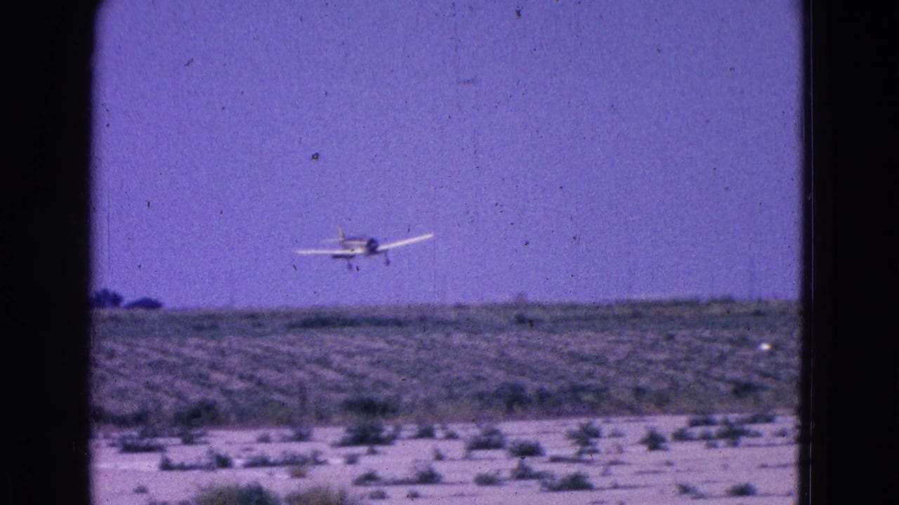 Small propeller plane descending toward a runway or open landing strip.