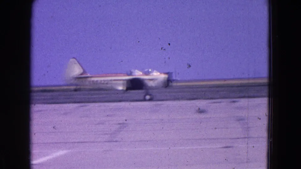 A small propeller plane is shown in side view at runway level, with possible occupants visible in the cockpit area.