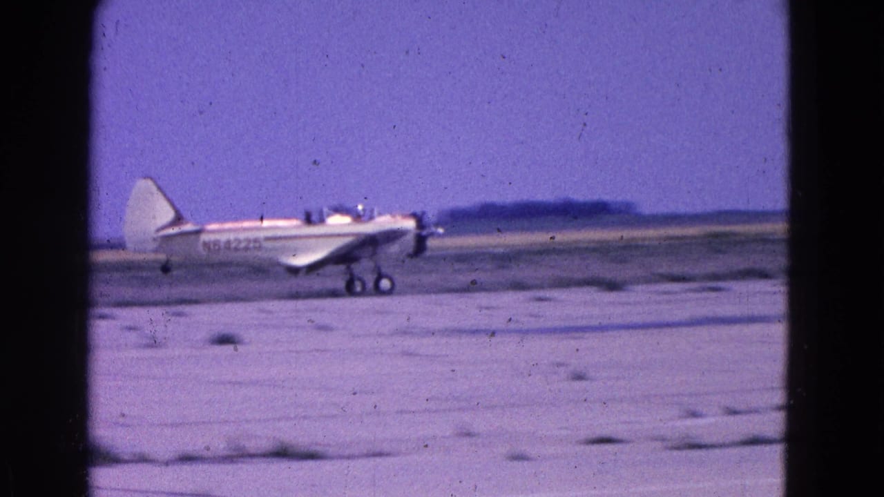 Small white propeller plane on a dirt runway beneath a blue-purple sky.