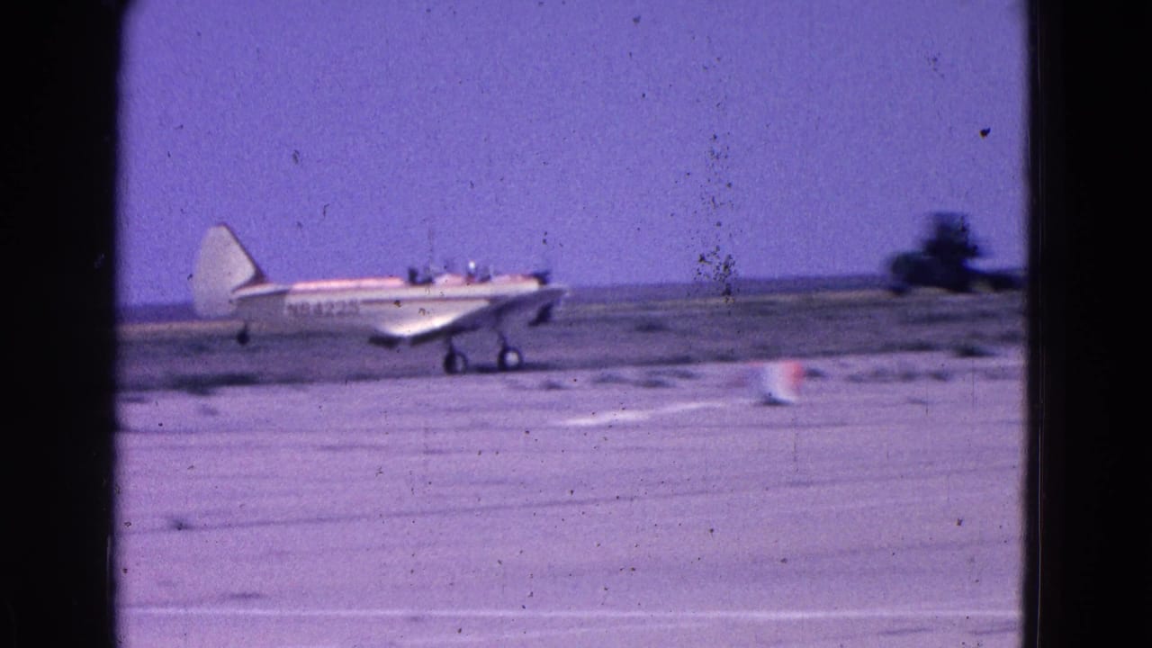 White light aircraft rolling along the runway with a cone nearby.