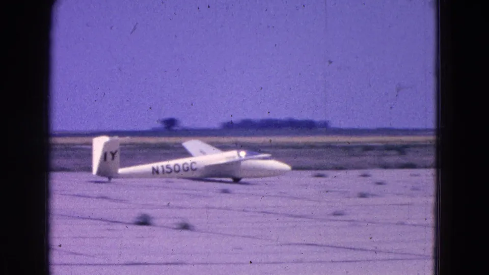 The final frame shows the N150GC glider still on or near the runway surface, with open field and low horizon behind it.