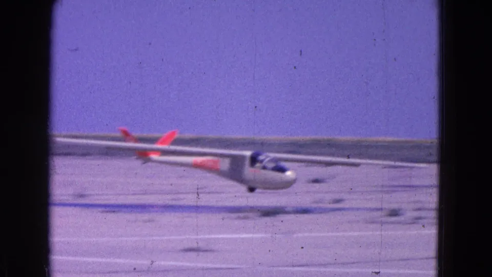 The glider moves close to the lens as it nears touchdown on a dirt runway in the Washington, DC area, filmed on 8mm in 1964.