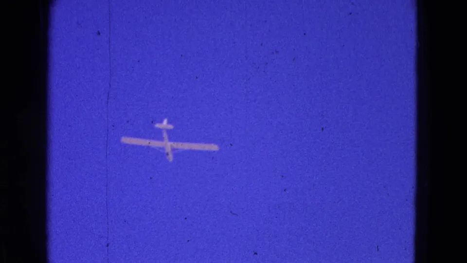 A white glider appears against a deep blue sky in 1964 8mm home-movie footage from the Washington, DC area.