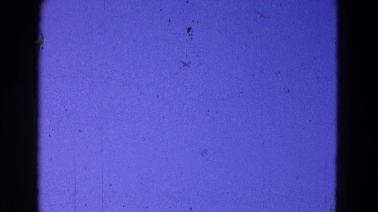 Deep blue-purple sky framed by dark vertical edges and faint film scratches.