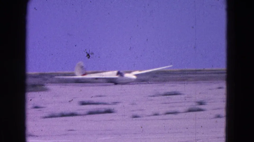 The glider moves across the Washington DC airfield scene, framed by 8mm gate borders and color-shifted sky.