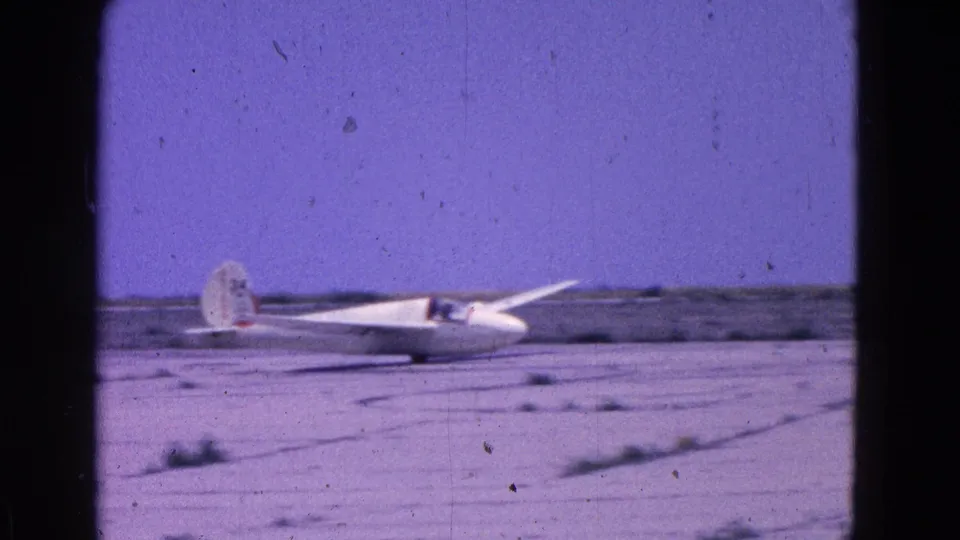 The glider appears on the ground at the end of its landing roll in the supplied 1964 Washington DC 8mm footage.