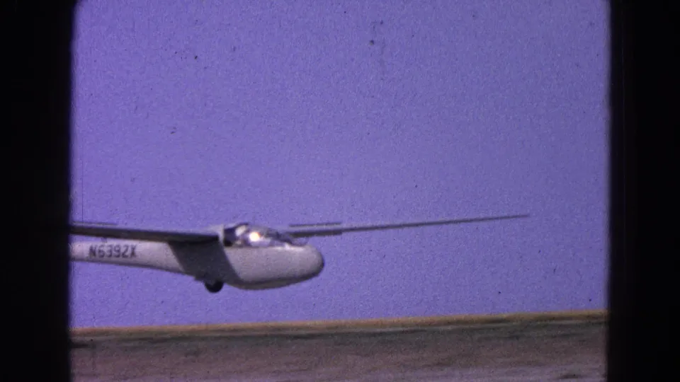 1964 8mm frame of a white glider marked N6392X low over a runway in the Washington, DC area.