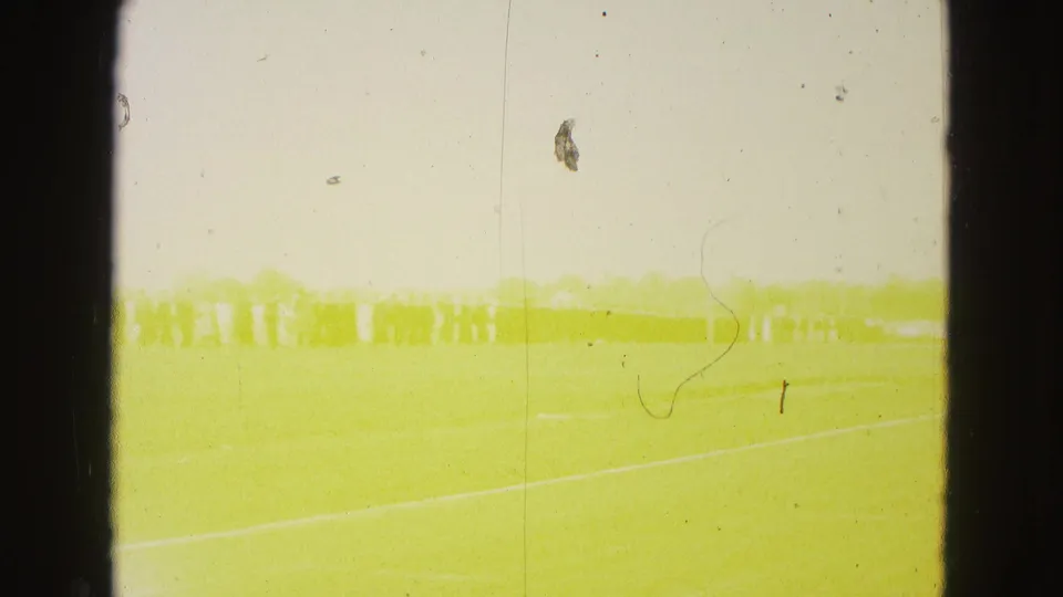 The final frame is heavily yellowed and overexposed, with the Williamsburg graduation procession still faintly visible across the field.