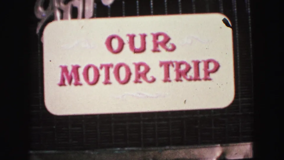A home-movie title card reading Our Motor Trip appears against the front grille area, confirming the personal travel-film framing.