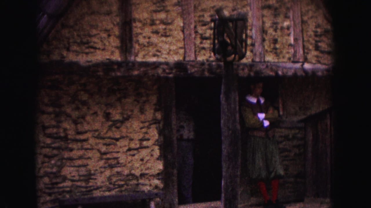 Rustic thatched building with a person standing near a dark doorway.