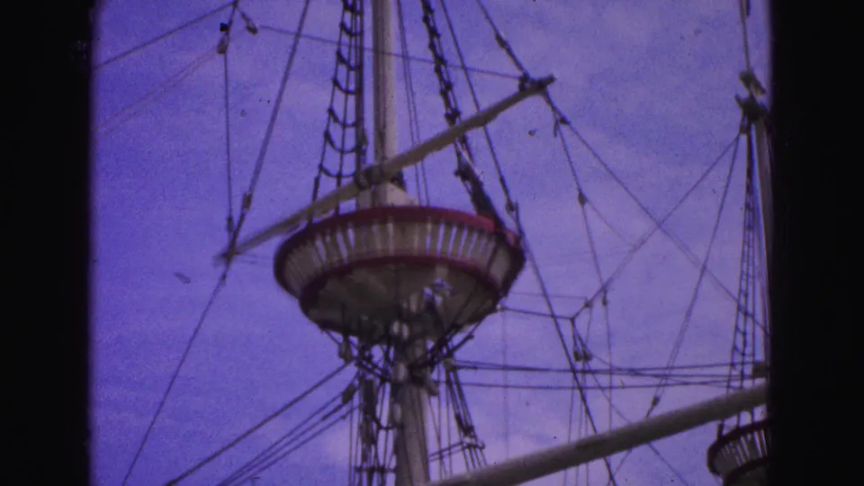 Upward 1964 Williamsburg home-movie view of the ship's crow's nest, mast, rope ladder, and rigging.
