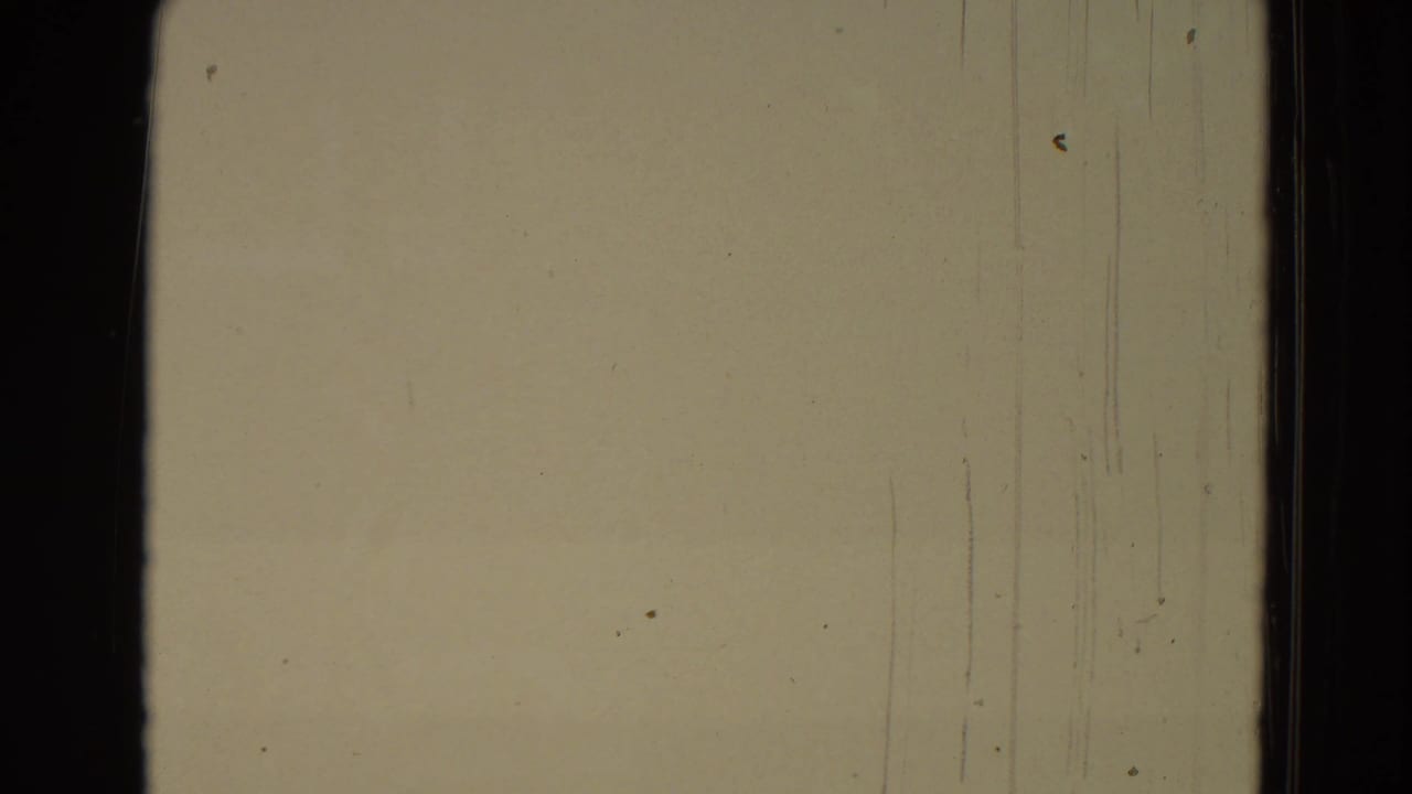 Overexposed beige frame from the 1965 8mm clip, showing film borders, scratches, and surface wear.