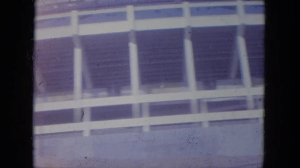 1965 Louisville frame showing the stadium facade with white columns, open seating shadows, and a concrete perimeter wall.