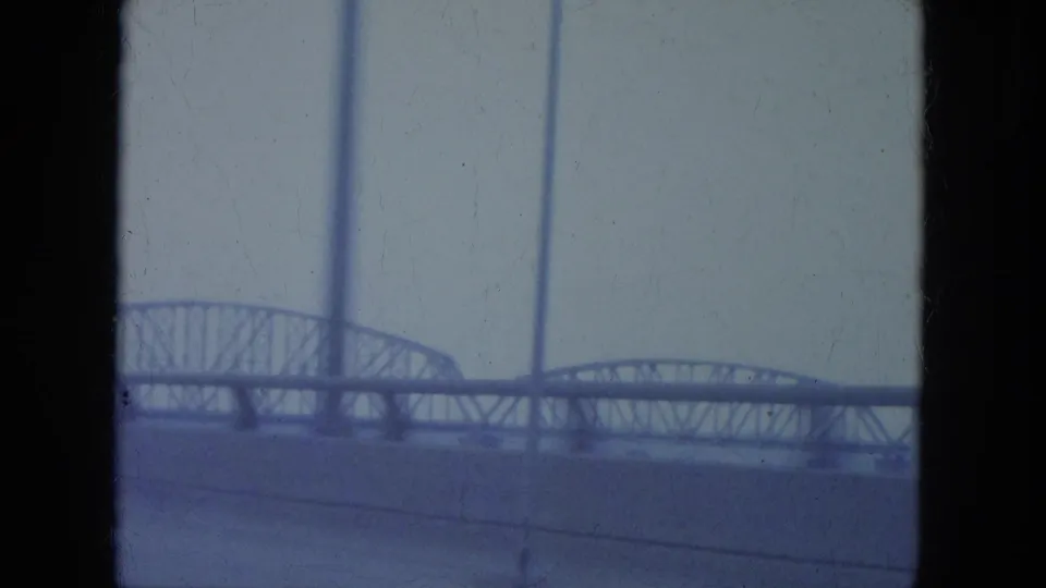 Soft 8mm Louisville frame showing a steel bridge span across the lower frame with vertical light poles and pale sky.