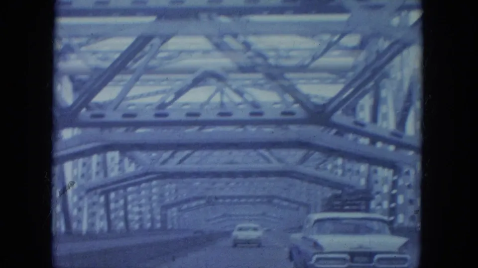 Final 1965 Louisville bridge-driving frame with cars under repeating steel trusses and visible 8mm gate edges.