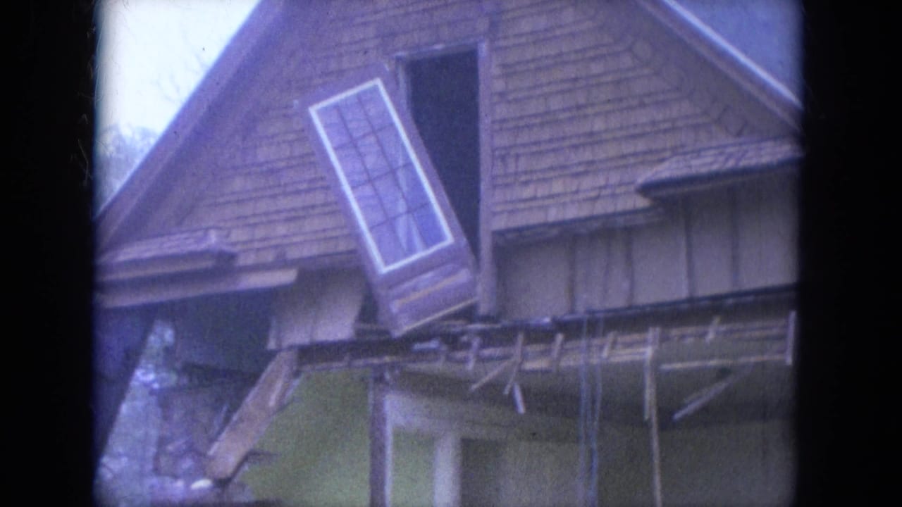 Close view of the same damaged roofline with a window assembly leaning outward from the upper wall.