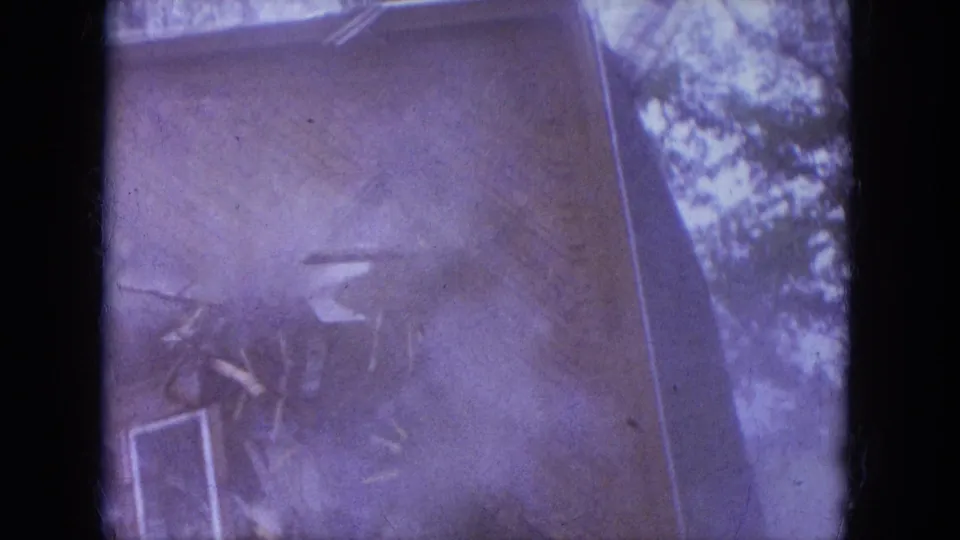 1965 Louisville 8mm frame showing dust and scattered debris obscuring much of the house as the demolition reaches a collapse moment.