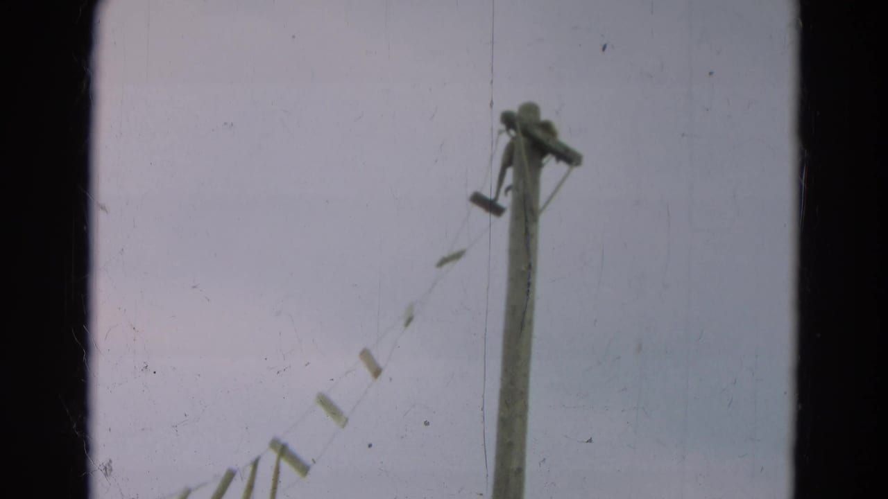 1965 Omaha 8mm frame with a tall wooden post and diagonal rope-supported bridge slats viewed from below.
