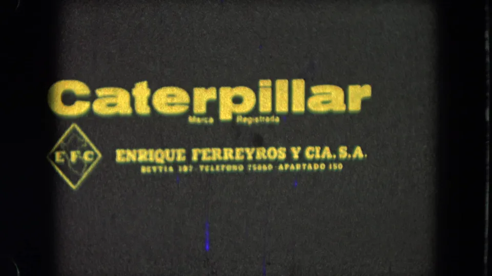 1965 8mm frame showing a Caterpillar title card and Enrique Ferreyros y Cia. S.A. text filmed from a projected or printed source.