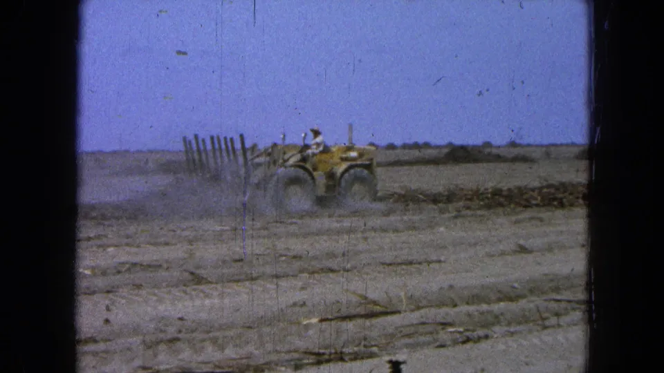 In the 1965 Pueblo, Mexico clip, a driver operates a yellow tractor as dust rises from the dry field.