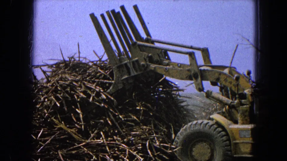 The loader’s claw and front wheel are seen at the debris pile in 1965 Pueblo, Mexico home-movie footage.