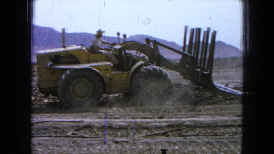 The 1965 Pueblo, Mexico footage shows the loader working a pile of poles while dust gathers around its wheels.