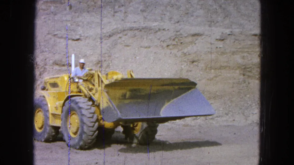 Mid-1960s 8mm footage shows the loader and operator moving through a quarry-like work area with the bucket extended.