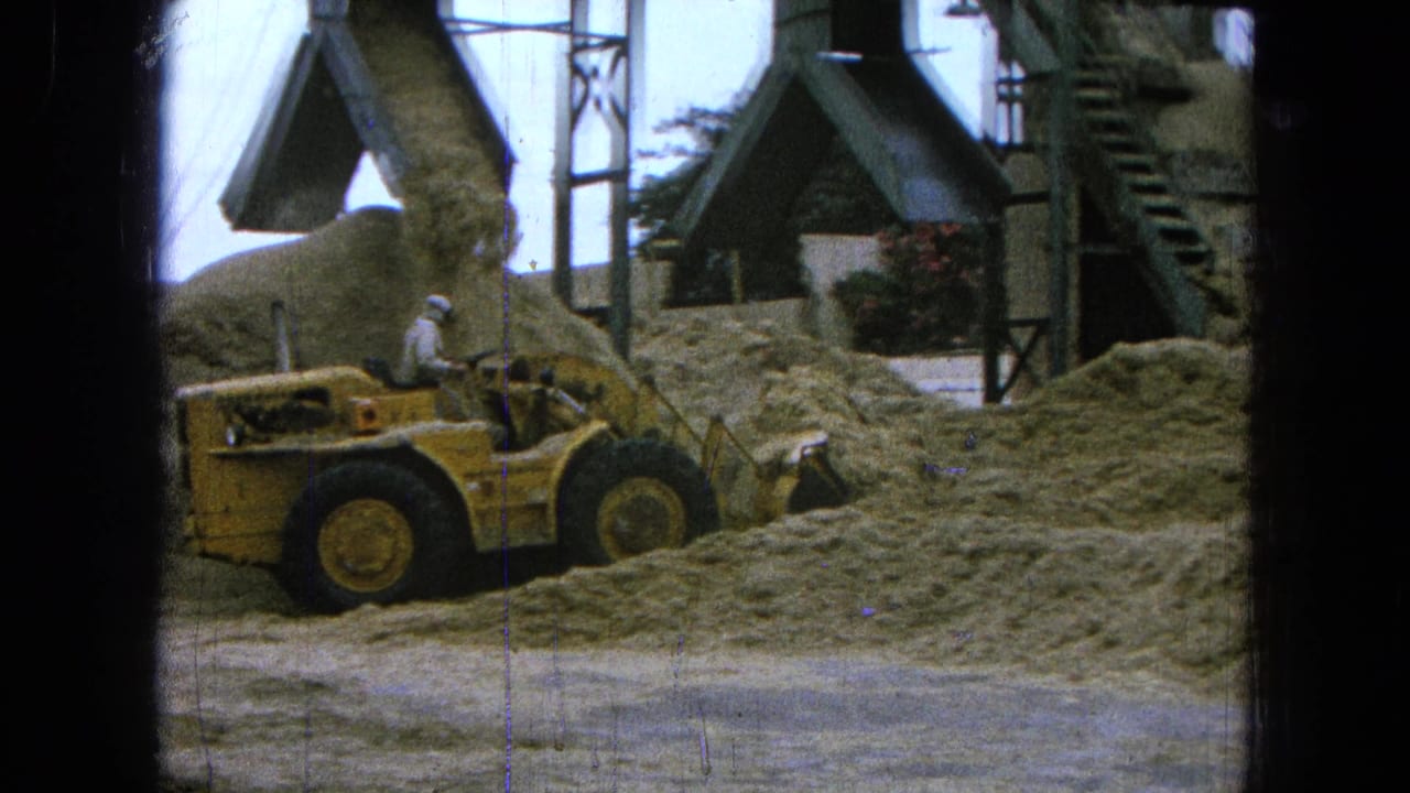 The 1965 Pueblo, Mexico 8mm frame shows the loader partly behind loose material as the chute adds to the pile.