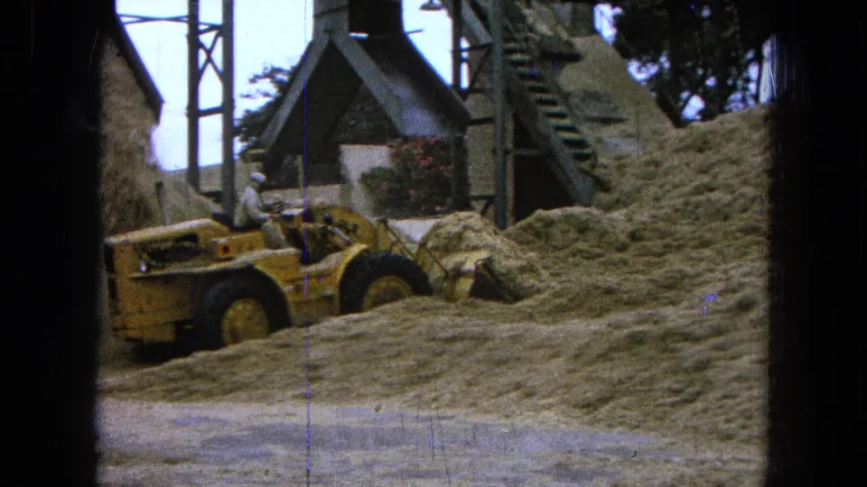 In the 1965 Pueblo, Mexico home-movie view, the loader is partly obscured by piled material near a metal stairway.