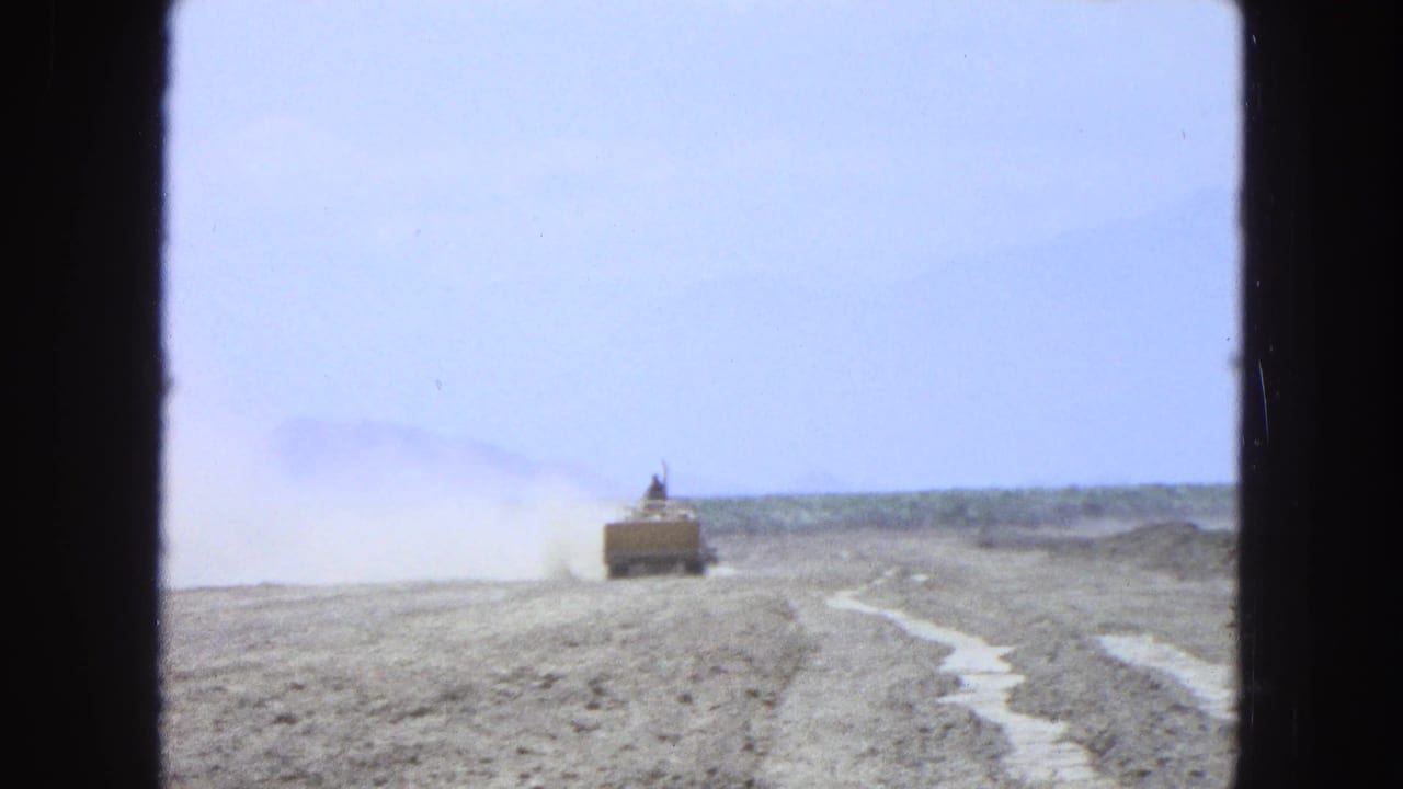 Distant tractor and tillage path in a dry Pueblo, Mexico field, filmed on soft 8mm color stock.