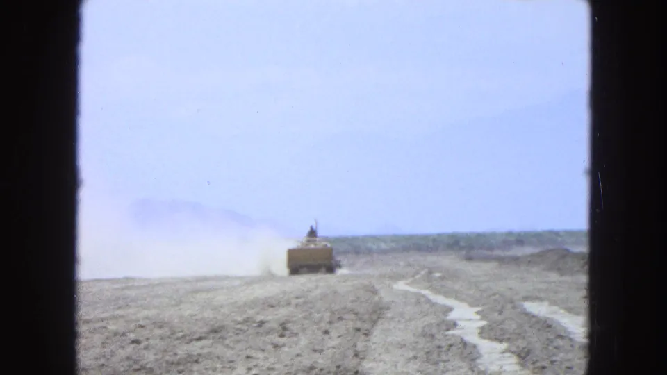 Distant tractor and tillage path in a dry Pueblo, Mexico field, filmed on soft 8mm color stock.