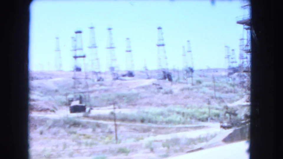 Blurry 1966 Barstow-area view of utility poles, power lines, and a road or hillside seen from a moving or handheld camera.