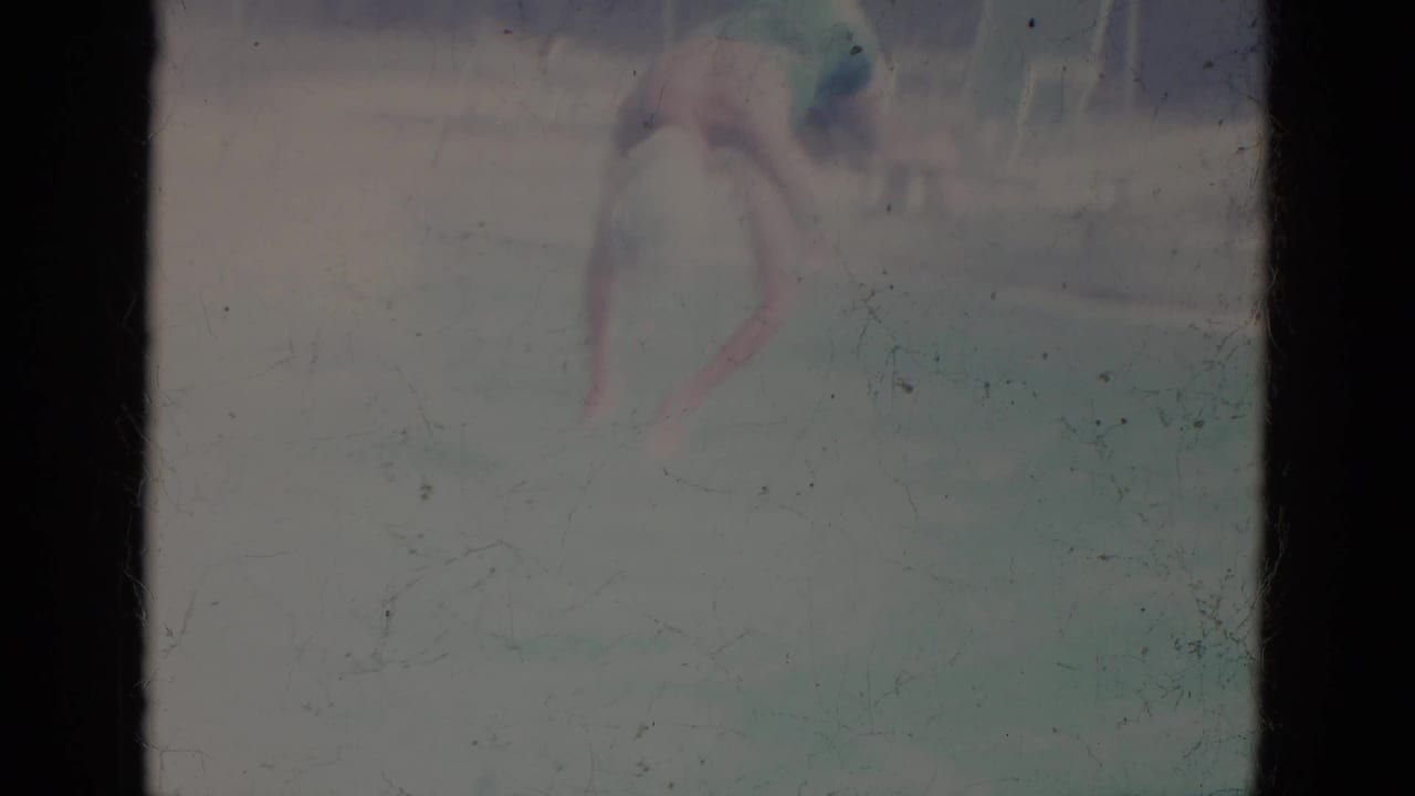 Faded frame of the swimmer entering or moving through the pool water.