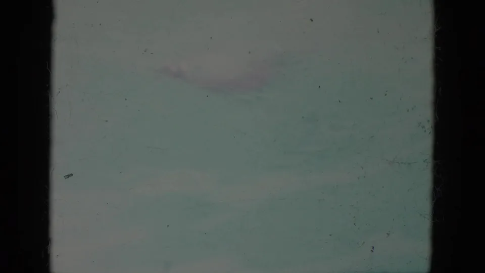 The swimmer is barely visible in turquoise pool water, with faded color and dark contact-sheet borders shaping the archival frame.