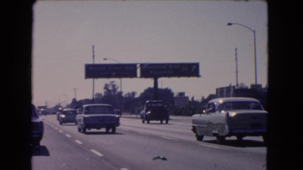 1966 California traffic passes under overhead signs for Walnut Grove Ave and Rosemead Blvd, with mid-century cars in several lanes.