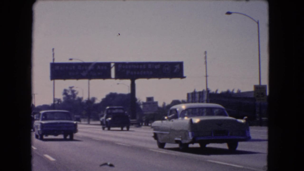 California freeway traffic in 1966, showing classic cars beneath Walnut Grove Ave and Rosemead Blvd signage from a moving-car perspective.
