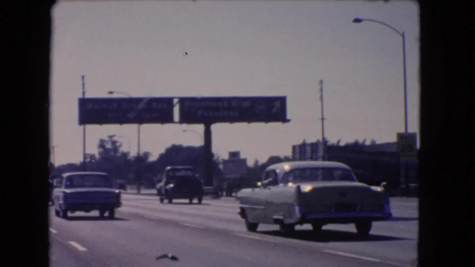 California freeway traffic in 1966, showing classic cars beneath Walnut Grove Ave and Rosemead Blvd signage from a moving-car perspective.
