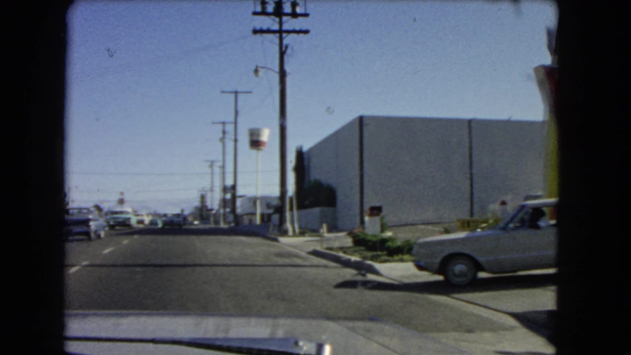 Roadside street with utility poles, cars, and a partial McDonald's arch at the edge.