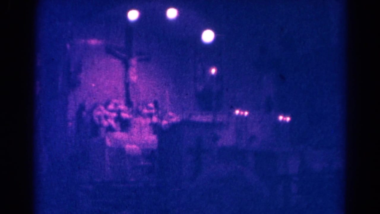 Danville, Illinois church service on 8mm film, with a central cross and congregation blurred by low light and grain.