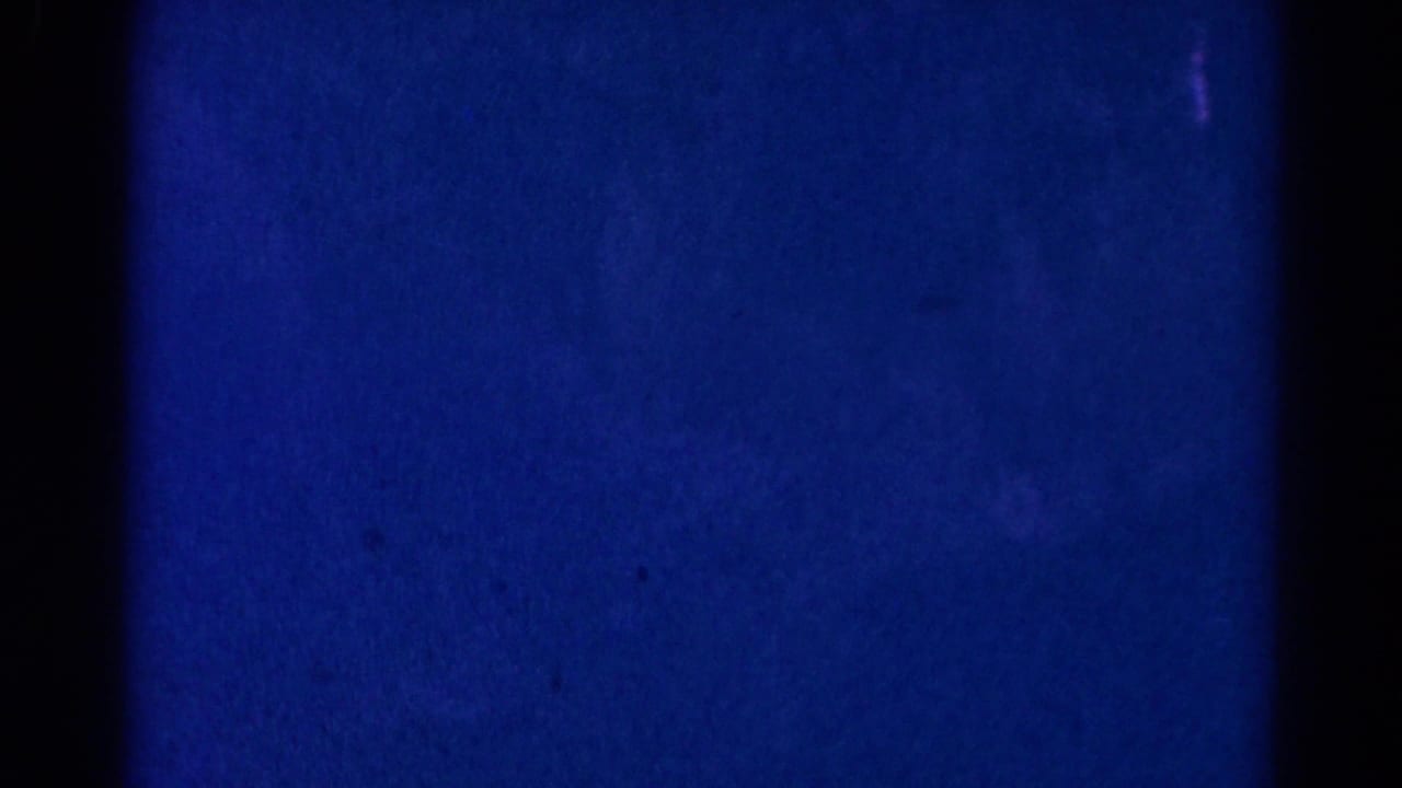 Blue and purple 8mm frame from the 1966 Danville church ceremony, with only faint interior shapes visible.
