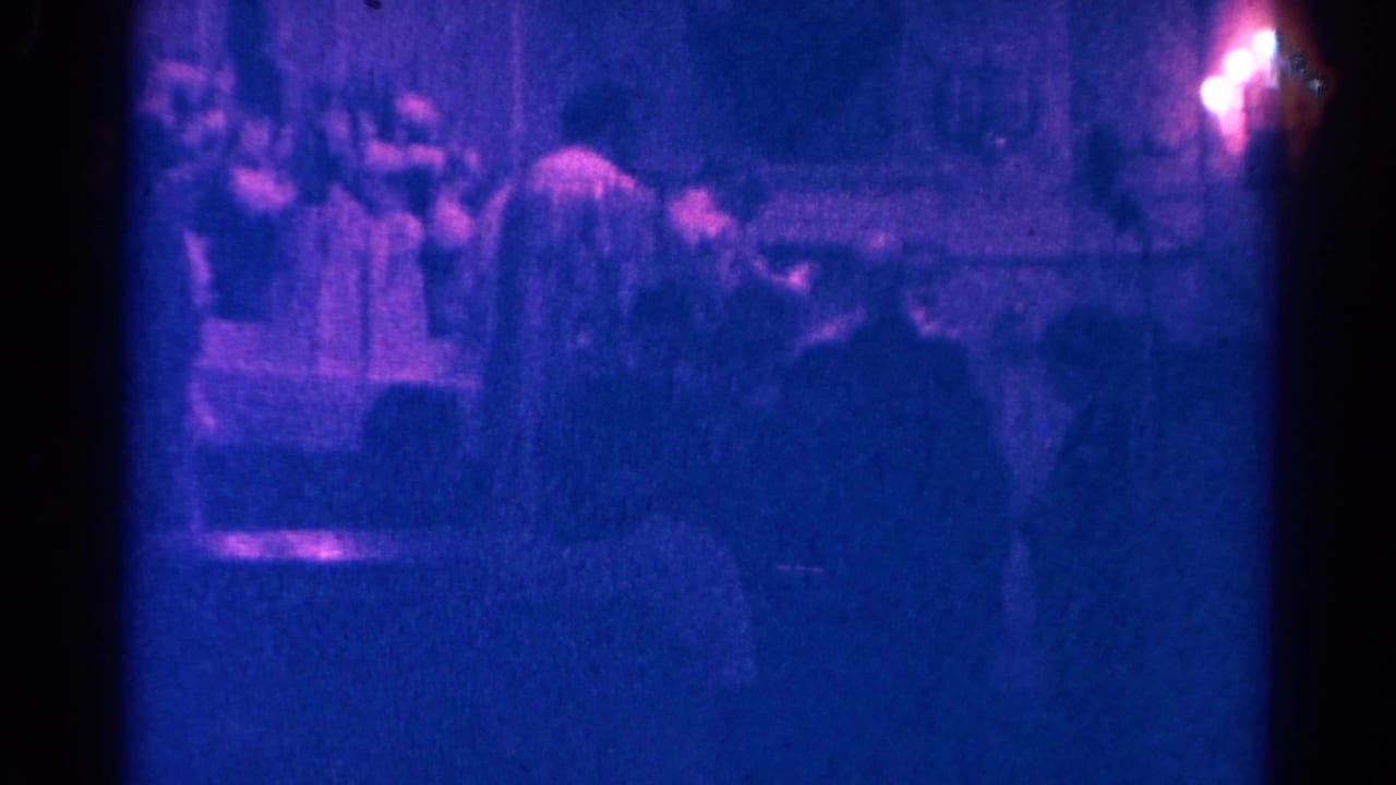 Dim church interior with seated congregants facing an altar and priest.