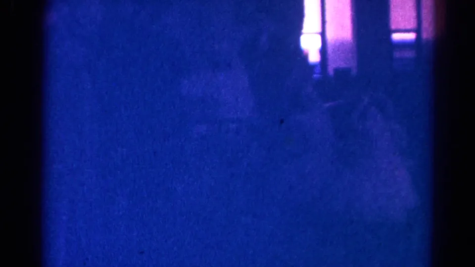 Very dark 1966 Danville church-service frame with worshipper silhouettes in pews and a bright lighted area at the side.