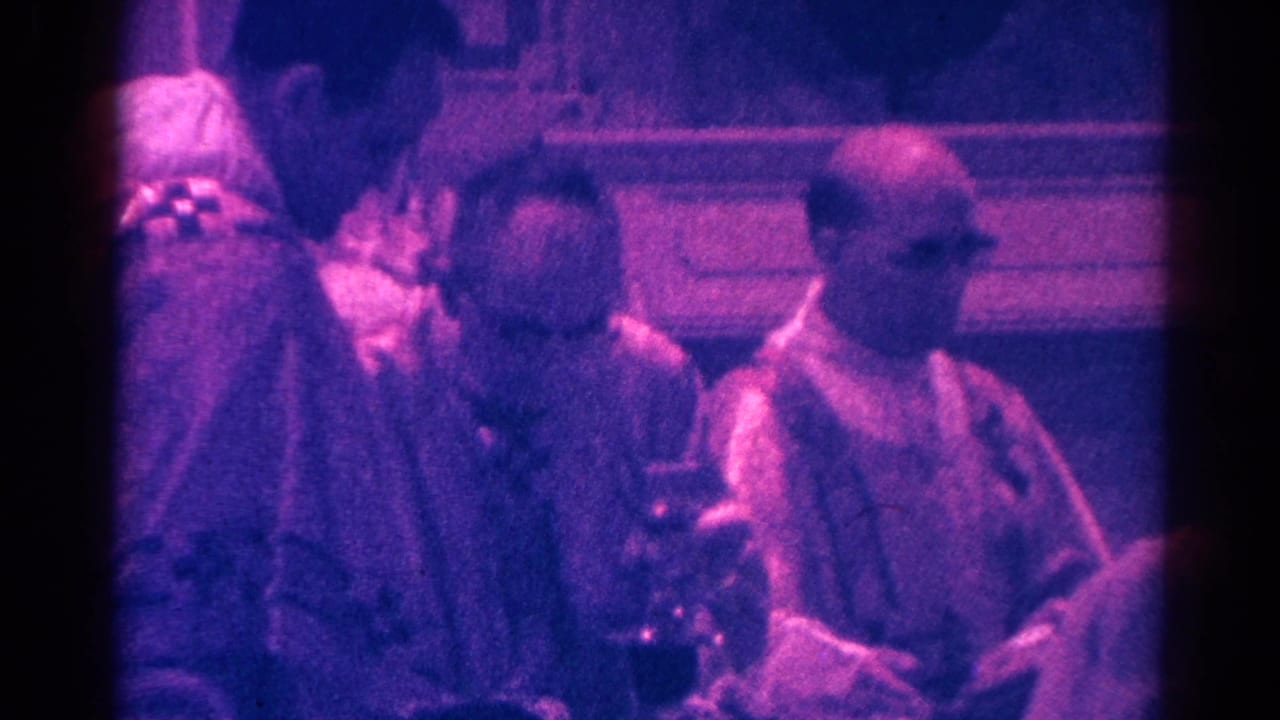 Priests in vestments stand near a chalice inside a church.