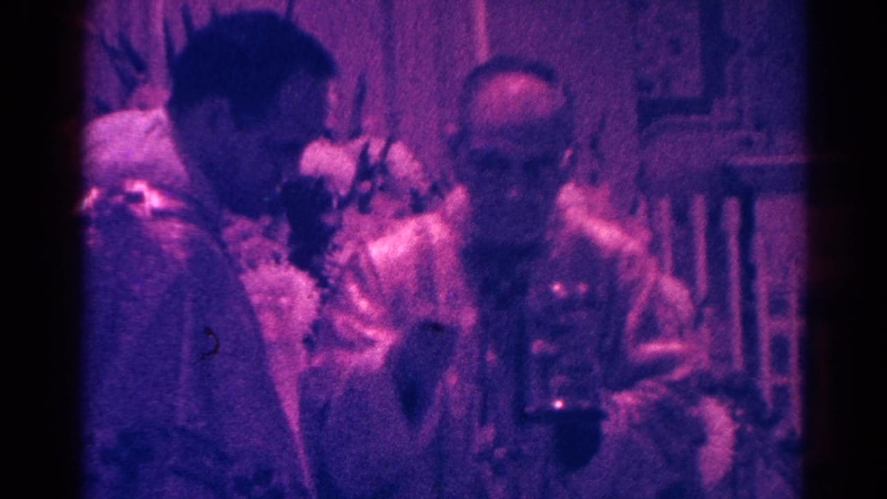 Priest in white vestments offering communion to a child near seated congregants.