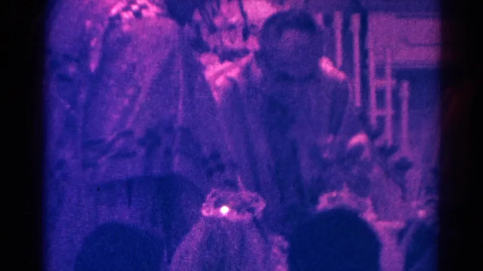 Soft 8mm frame from the Danville communion service with congregants, a child, and church furnishings visible.
