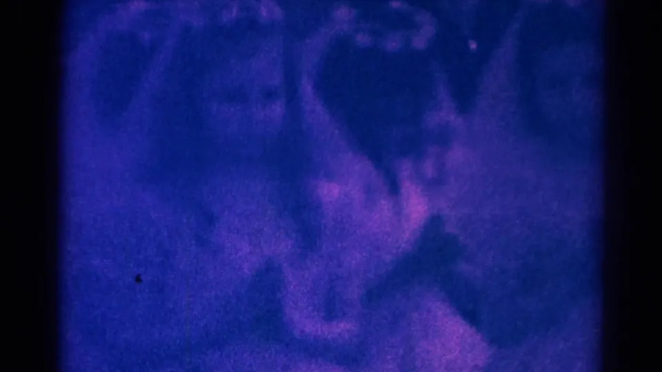 Soft 8mm frame from the 1966 Danville church ceremony, with children in light clothing partly obscured by blur and tint.